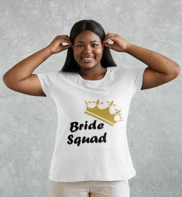 A girl wearing a white T-shirt that says "Bride Squad" with a gold crown hovering over -ide in the Bride