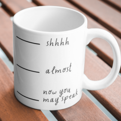 11 oz White mug that has the writing "Shhh... almost... now you may speak" at 3 different vertical spots on the mug