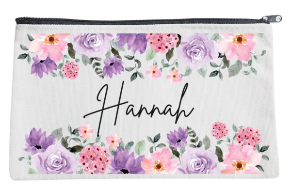 Three personalized pouches with A name written on them, adorned with different floral designs.