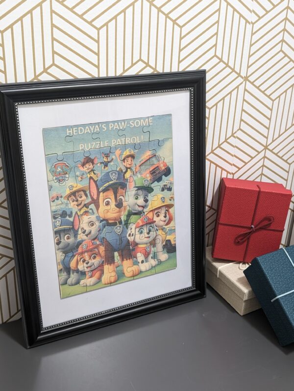 Framed Paw Patrol wooden puzzle keepsake displayed against a patterned wall.