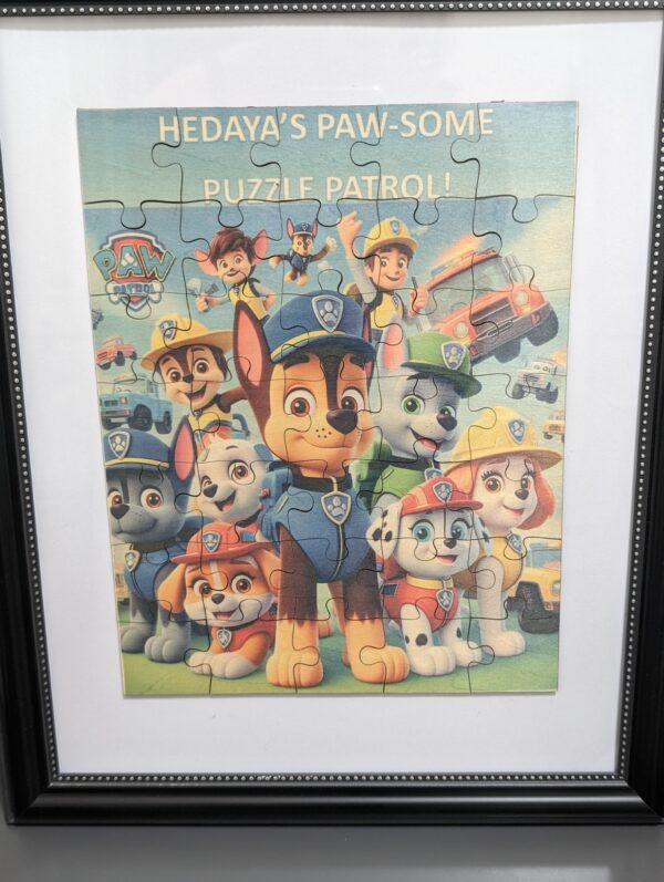 Framed Paw Patrol wooden puzzle keepsake displayed against a patterned wall.